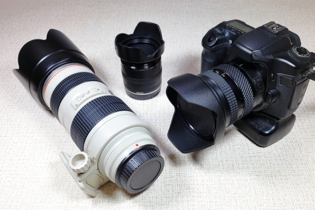 一眼レフカメラと高倍率の交換用レンズが並んでいる