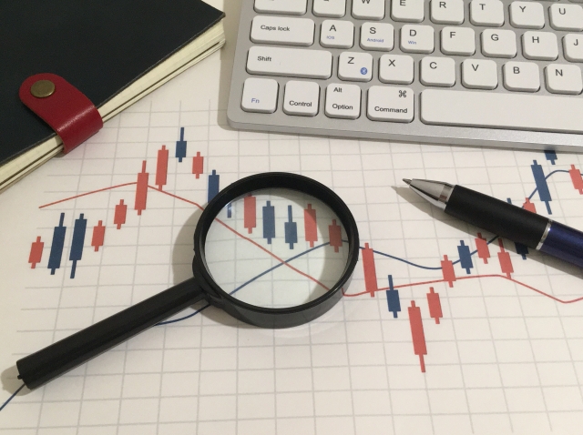 株価チャートに虫眼鏡が当たっている