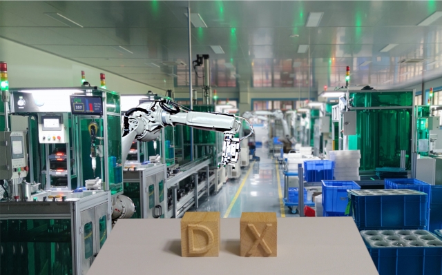 産業ロボットを使った製造現場とDXと書かれた木のブロックが置いてある