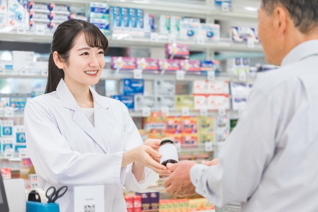 ドラッグストアで医薬品を手渡す女性薬剤師