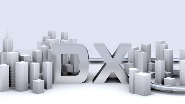 白を基調とした都市モデルの中にDXという文字のブロックが置かれている